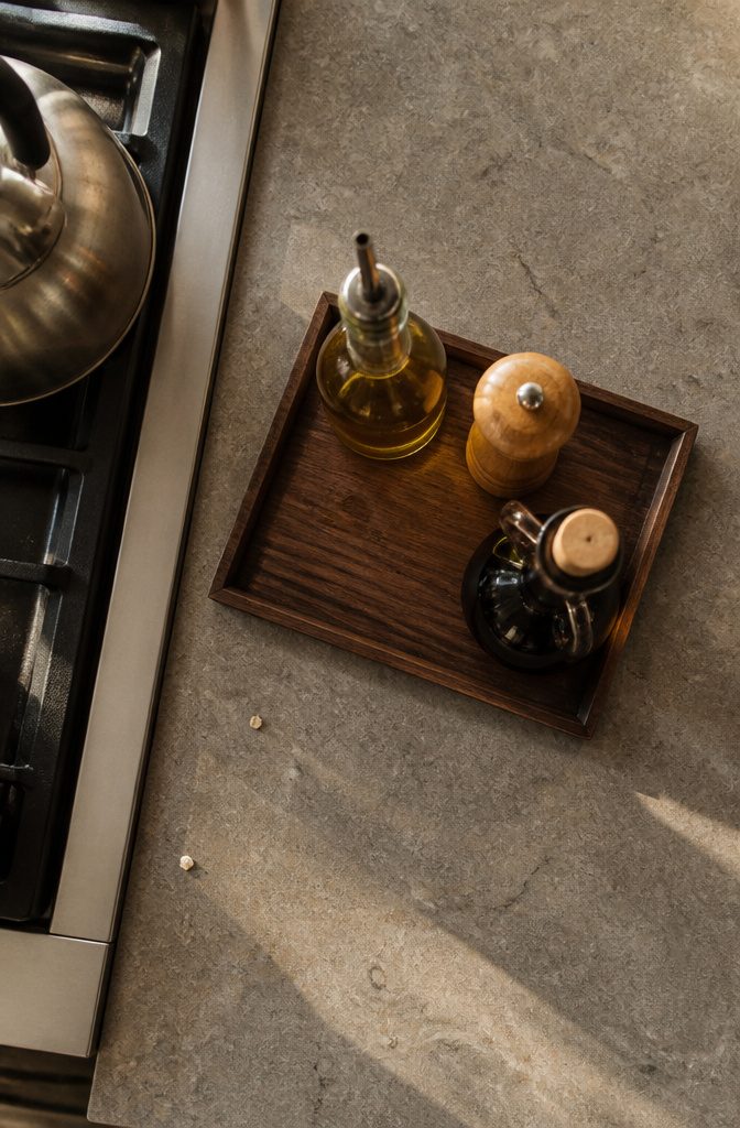 15 Ways to Decorate Your Kitchen Counters Without Clutter 3 Serving board holding olive oil and seasonings on a kitchen counter