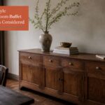 Dining room buffet beneath wall art with decorative objects arranged across its top